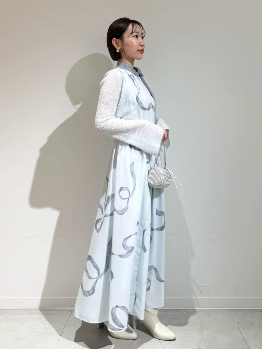 ブルー系のワンピース、ゴールド系のピアス（両耳用）を着用したレディースの冬コーディネートの6枚目の写真