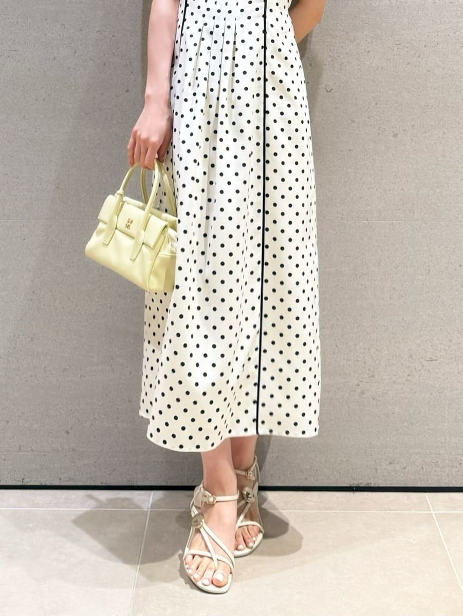 イエロー系のボストンバッグ、ホワイト系のワンピースを着用したレディースの春コーディネートの5枚目の写真