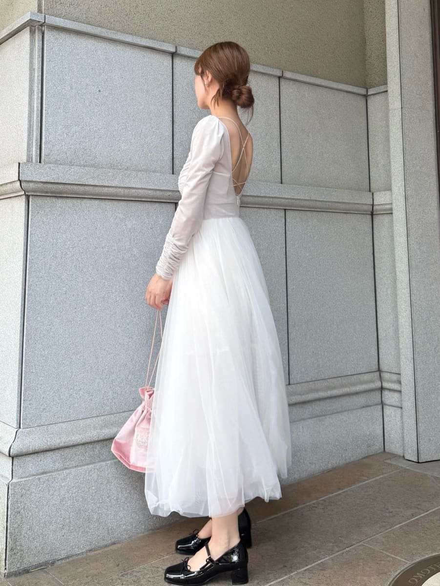 ホワイト系のワンピース、ピンク系のハンドバッグ、ブラック系のパンプスを着用したレディースの夏コーディネートの5枚目の写真