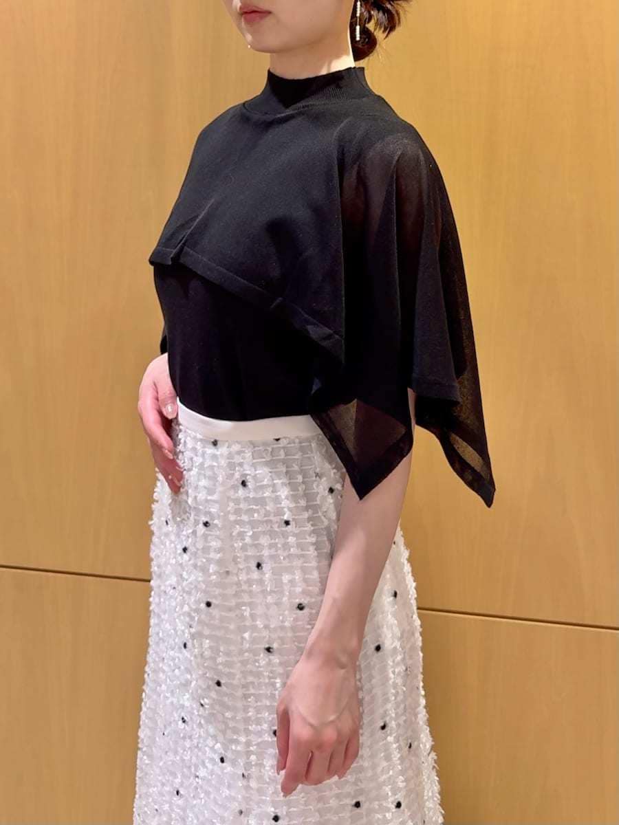 ブラック系のパンプス、ブラック系のハンドバッグ、その他のイヤリングを着用したレディースの春コーディネートの5枚目の写真