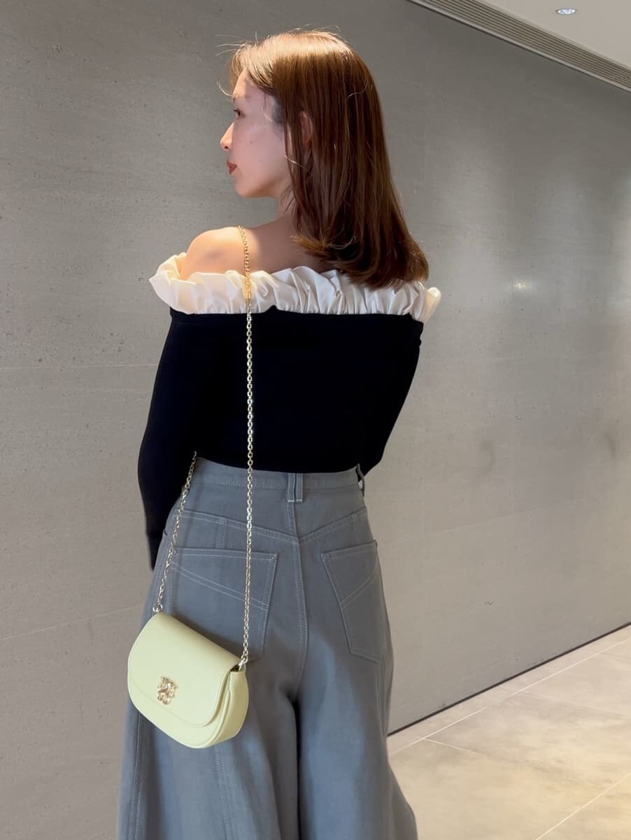グレー系のデニムパンツ、ブラック系のニット/セーター、イエロー系のショルダーバッグを着用したレディースの冬コーディネートの4枚目の写真