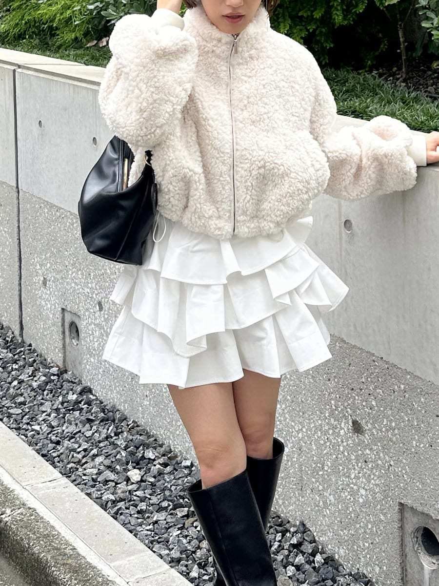 ホワイト系のその他パンツ、ブラック系のブーツ、ブラック系のショルダーバッグを着用したレディースの秋コーディネートの2枚目の写真