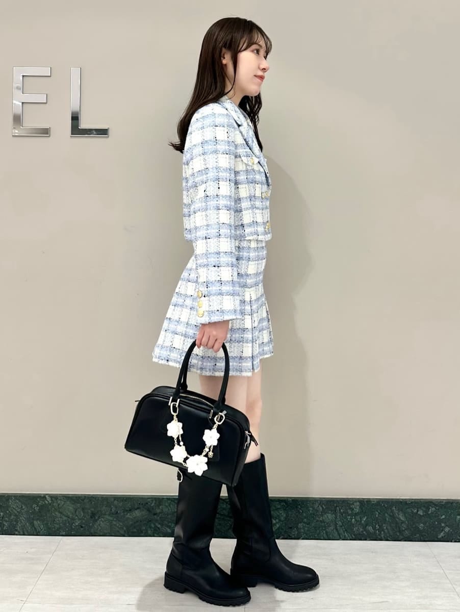 ブルー系のテーラードジャケット、ブルー系のスカート、ブラック系のボストンバッグを着用したレディースの春コーディネートの3枚目の写真