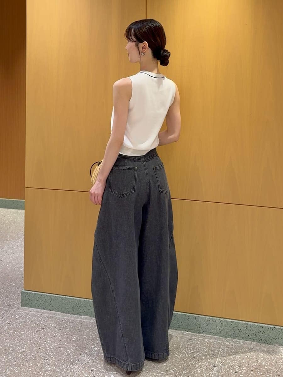 ブラック系のかごバッグ、ブラック系のデニムパンツ、ホワイト系のニット/セーターを着用したレディースの夏コーディネートの3枚目の写真
