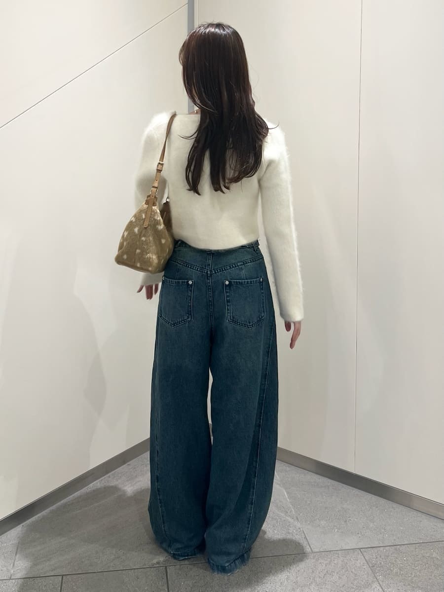 ホワイト系のノーカラージャケット、ブルー系のデニムパンツ、ホワイト系のキャミソールを着用したレディースの秋コーディネートの3枚目の写真