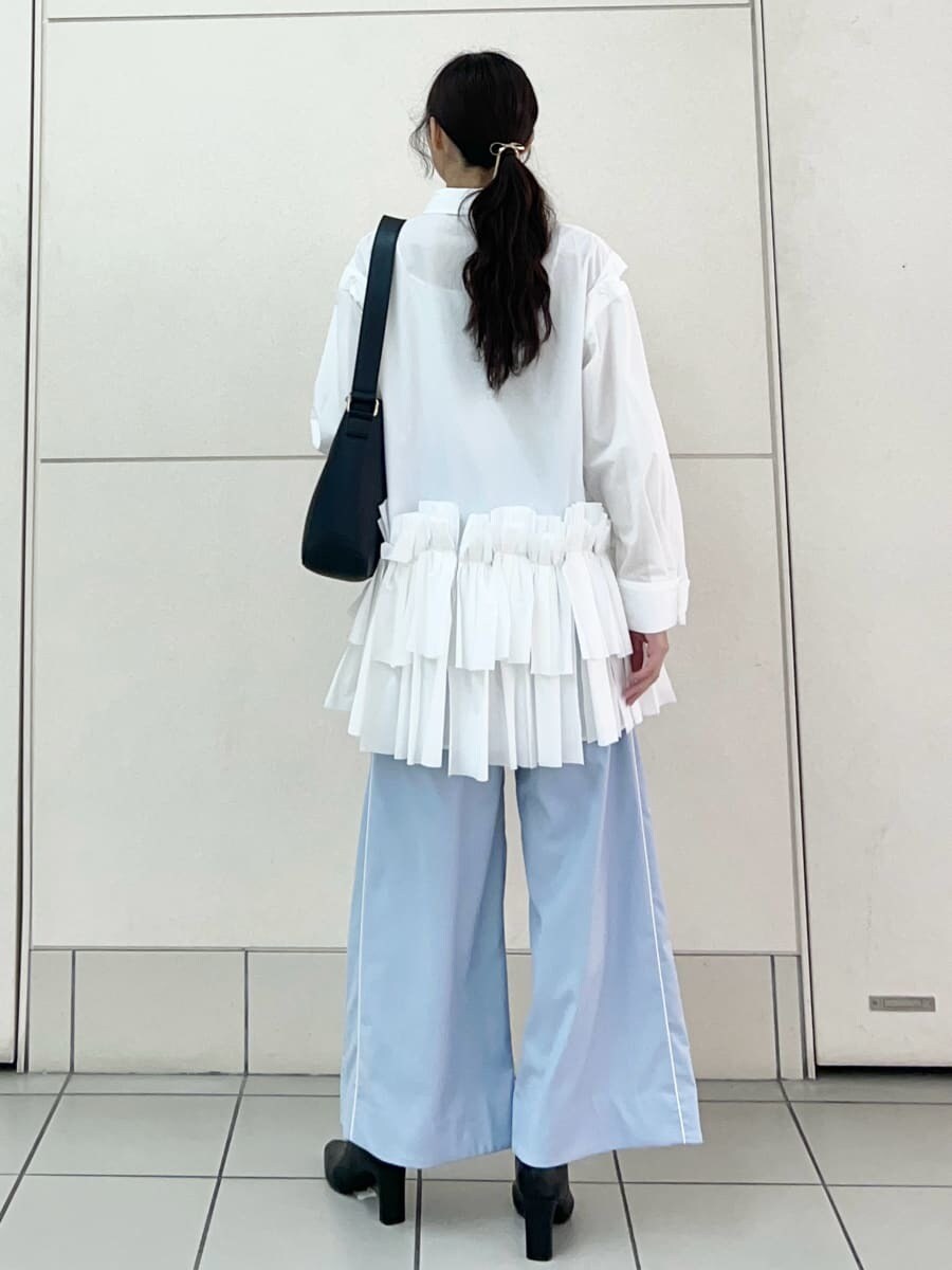 ホワイト系のワンピース、ブルー系のその他パンツ、ブラック系のブーツを着用したレディースの秋コーディネートの4枚目の写真