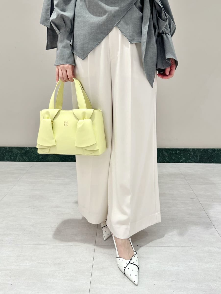 ホワイト系のその他パンツ、その他のパンプス、イエロー系のハンドバッグを着用したレディースの冬コーディネートの3枚目の写真