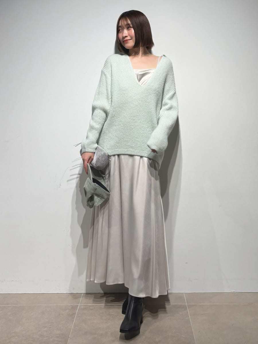 グレー系のブーツ、グリーン系のワンピース、グリーン系のキャップを着用したレディースの冬コーディネートの2枚目の写真