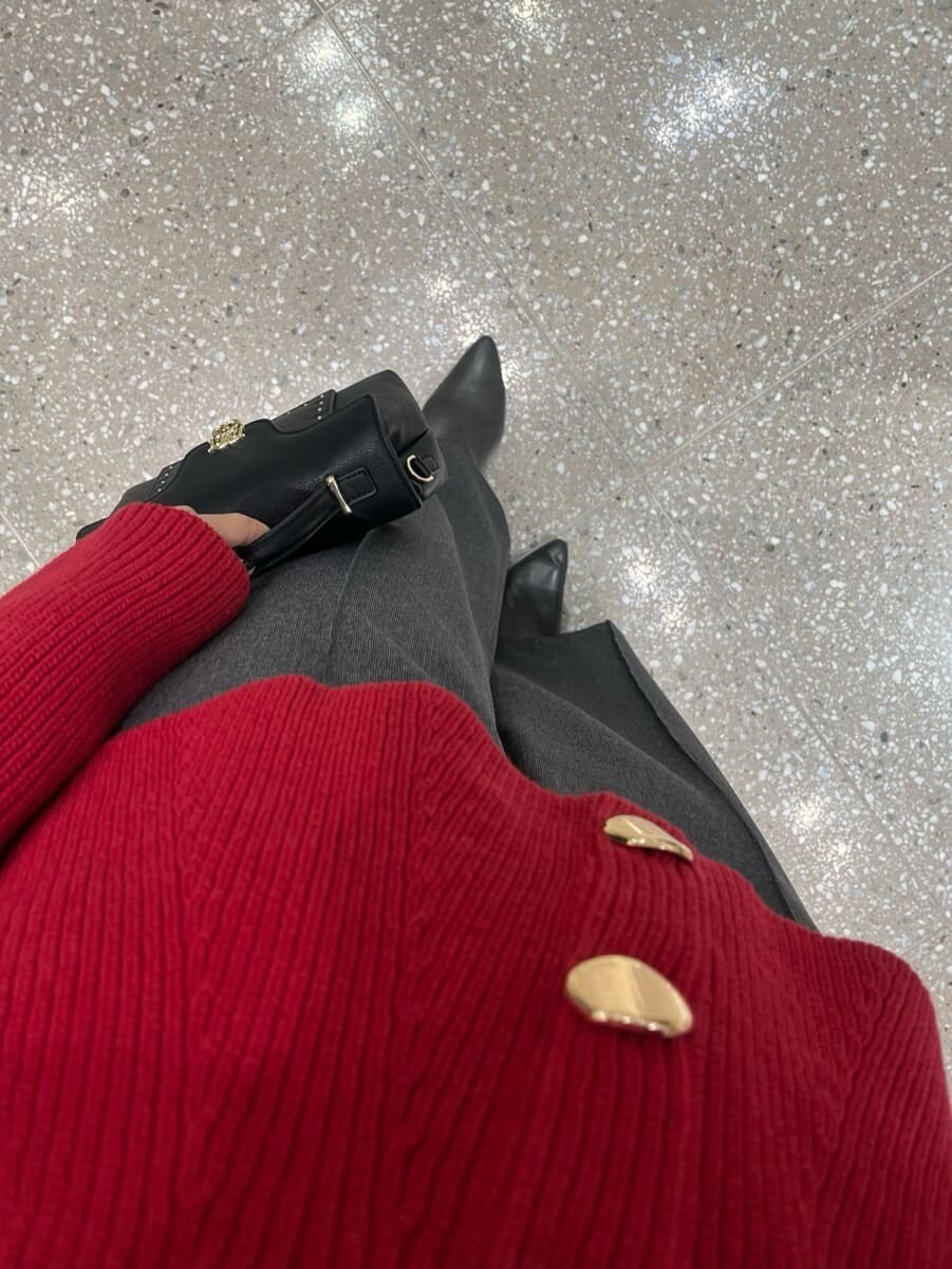 レッド系のニット/セーター、グレー系のその他パンツ、ブラック系のショルダーバッグを着用したレディースの秋コーディネートの4枚目の写真