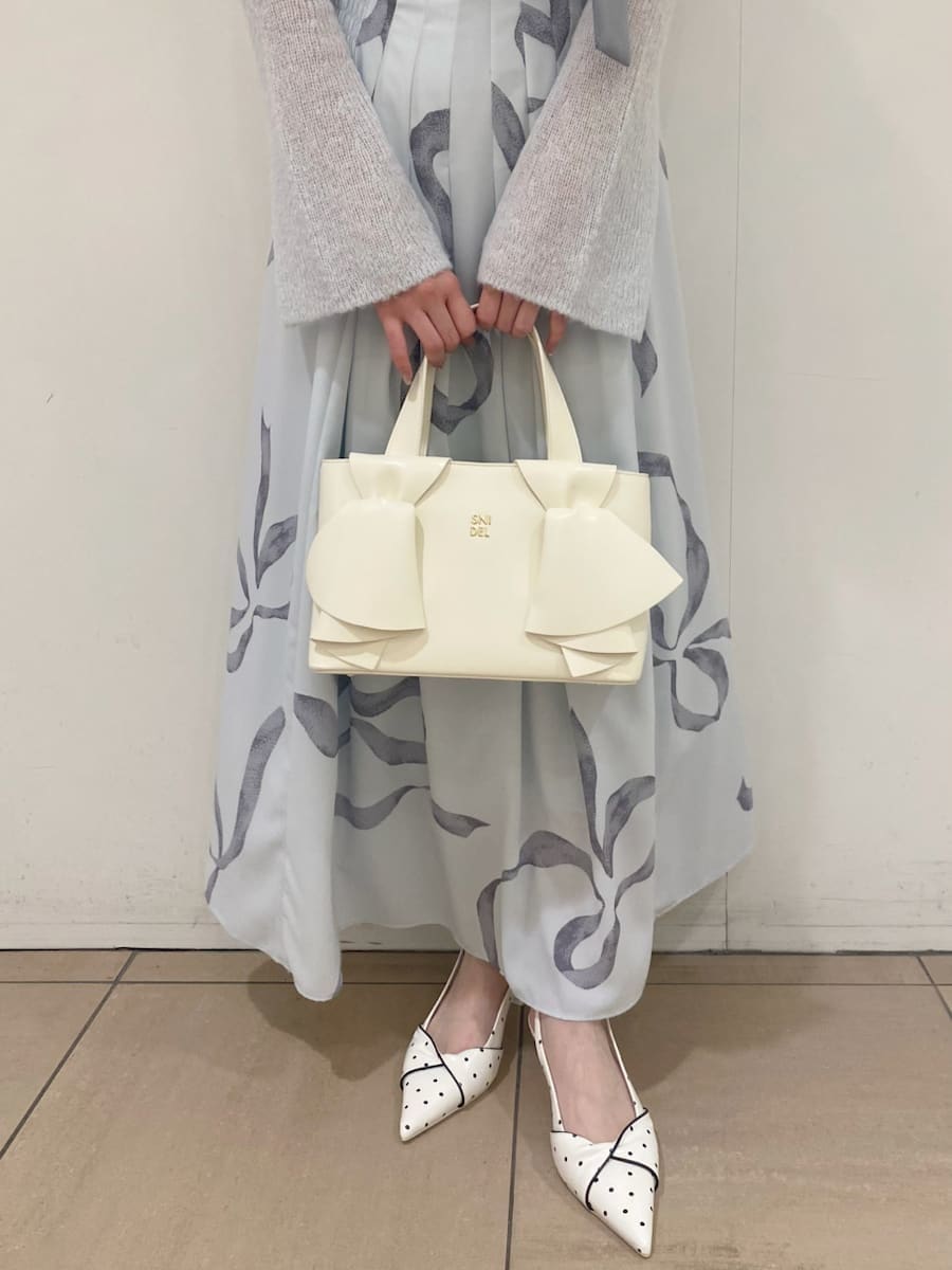 ブルー系のワンピース、その他のパンプス、ホワイト系のハンドバッグを着用したレディースの冬コーディネートの5枚目の写真