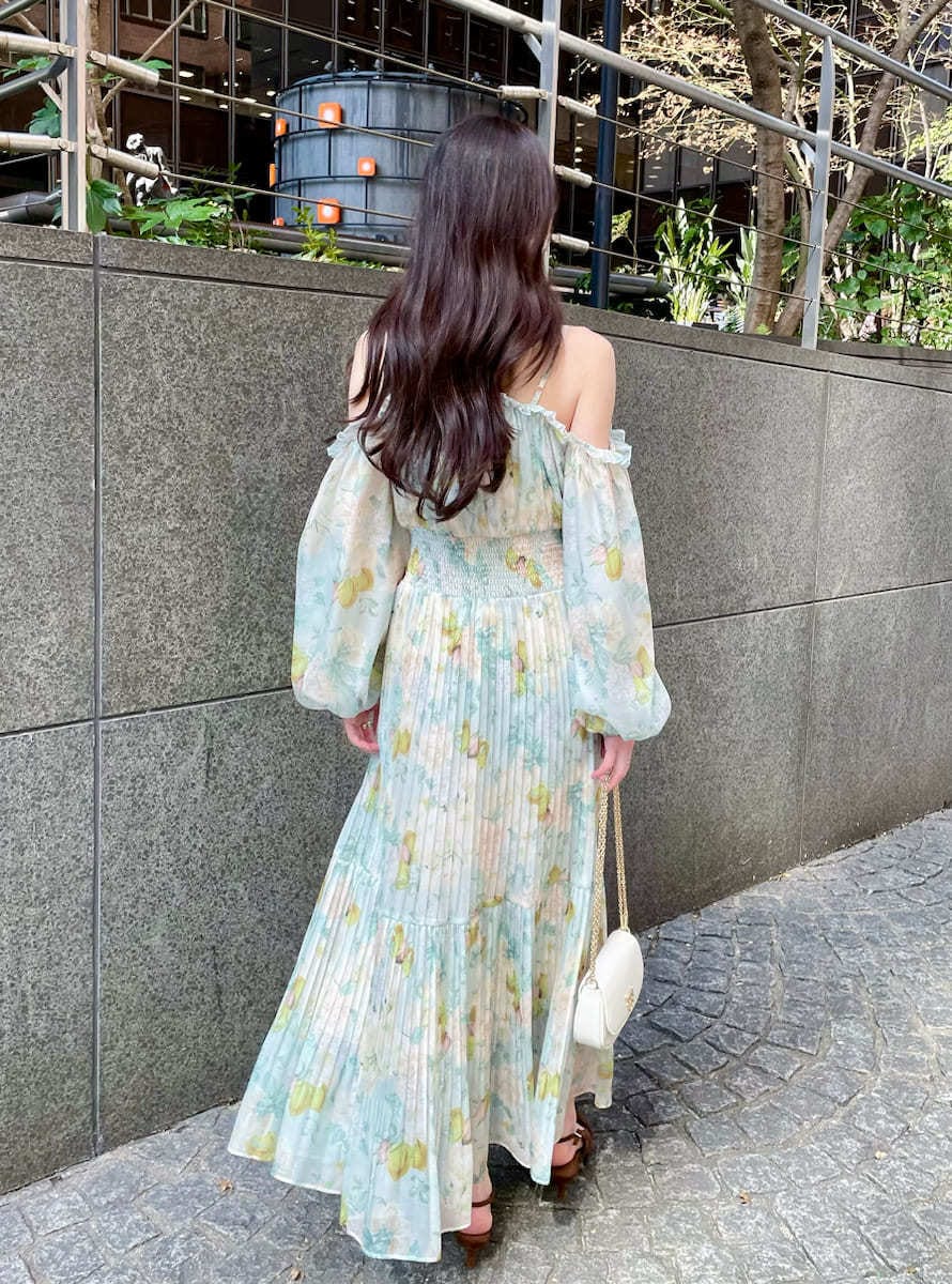 グリーン系のワンピース、ブラウン系のパンプス、ホワイト系のショルダーバッグを着用したレディースの春コーディネートの3枚目の写真