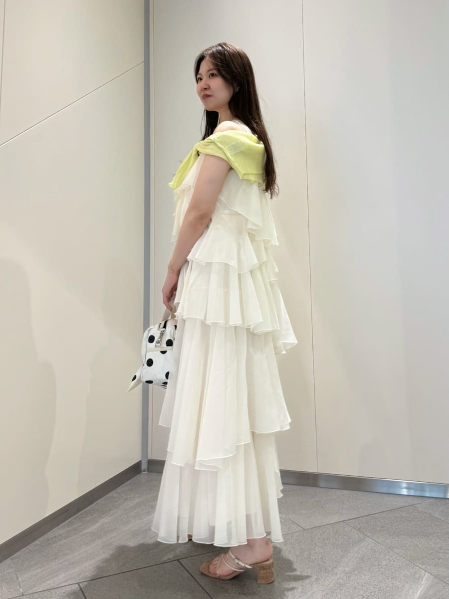 イエロー系のカーディガン/ボレロ、ホワイト系のショルダーバッグ、ホワイト系のドレスを着用したレディースの夏コーディネートの3枚目の写真