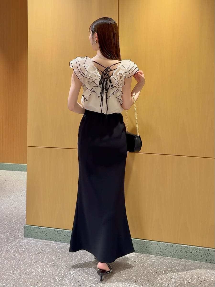 ブラック系のスカート、ベージュ系のシャツ/ブラウス、ブラック系のパンプスを着用したレディースの春コーディネートの3枚目の写真