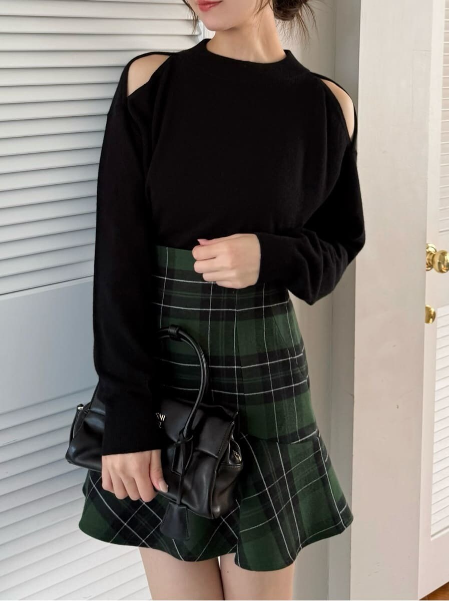 ブラック系のニット/セーター、グレー系のブーツ、ブラック系のダウンジャケット/コートを着用したレディースの秋コーディネートの2枚目の写真