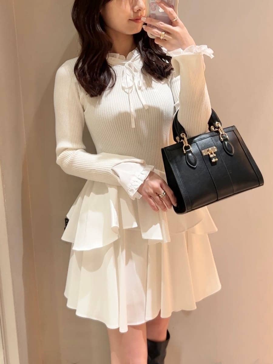 ホワイト系のワンピース、ブラック系のハンドバッグ、ブルー系のマフラーを着用したレディースの冬コーディネートの8枚目の写真