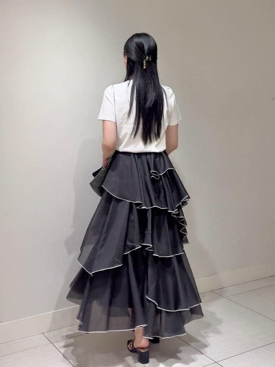 ブラック系のサンダル、ブラック系のスカート、ホワイト系のTシャツ/カットソーを着用したレディースの夏コーディネートの3枚目の写真