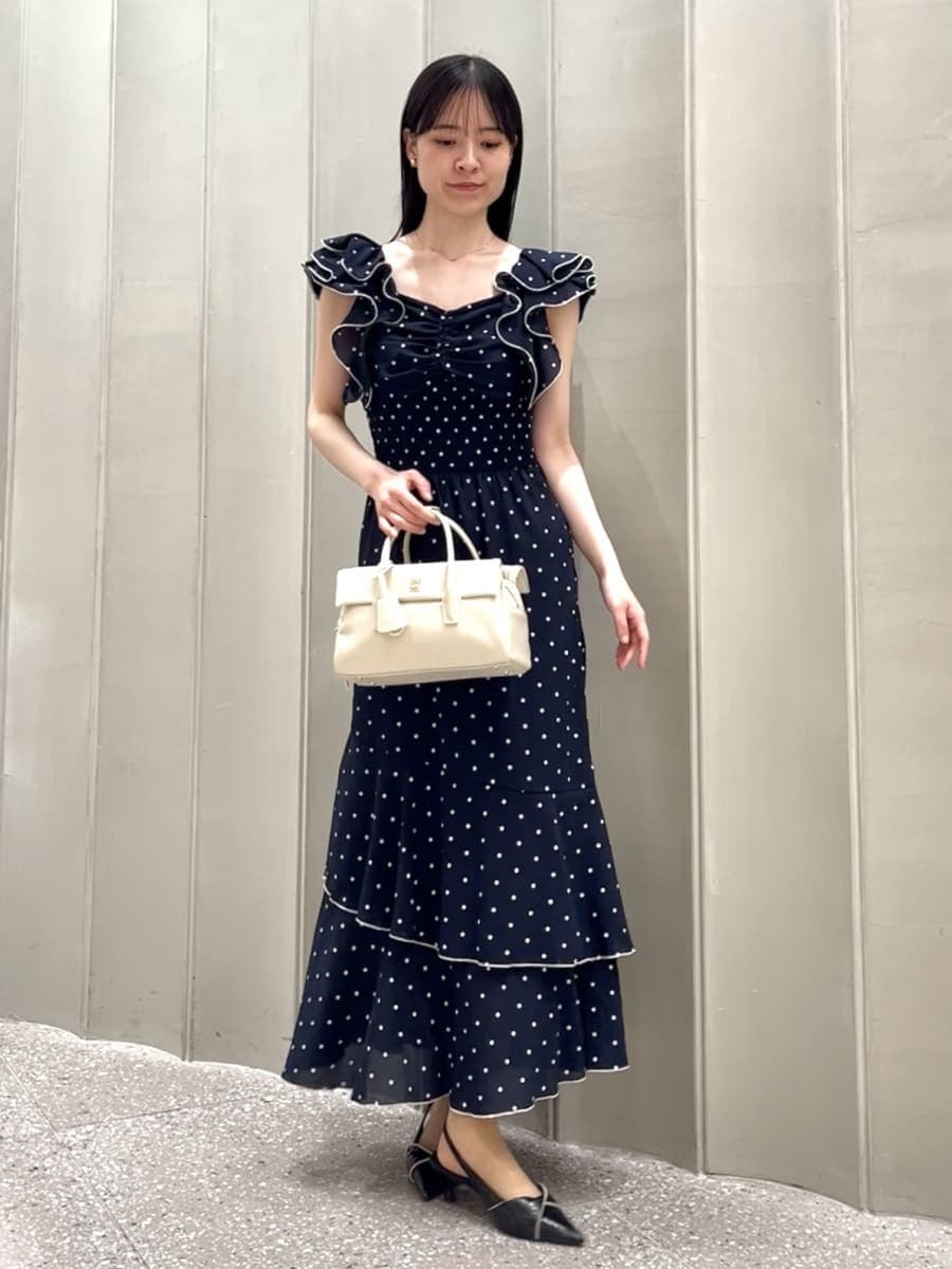 ブラック系のパンプス、ホワイト系のボストンバッグ、ブルー系のワンピースを着用したレディースの春コーディネートの4枚目の写真