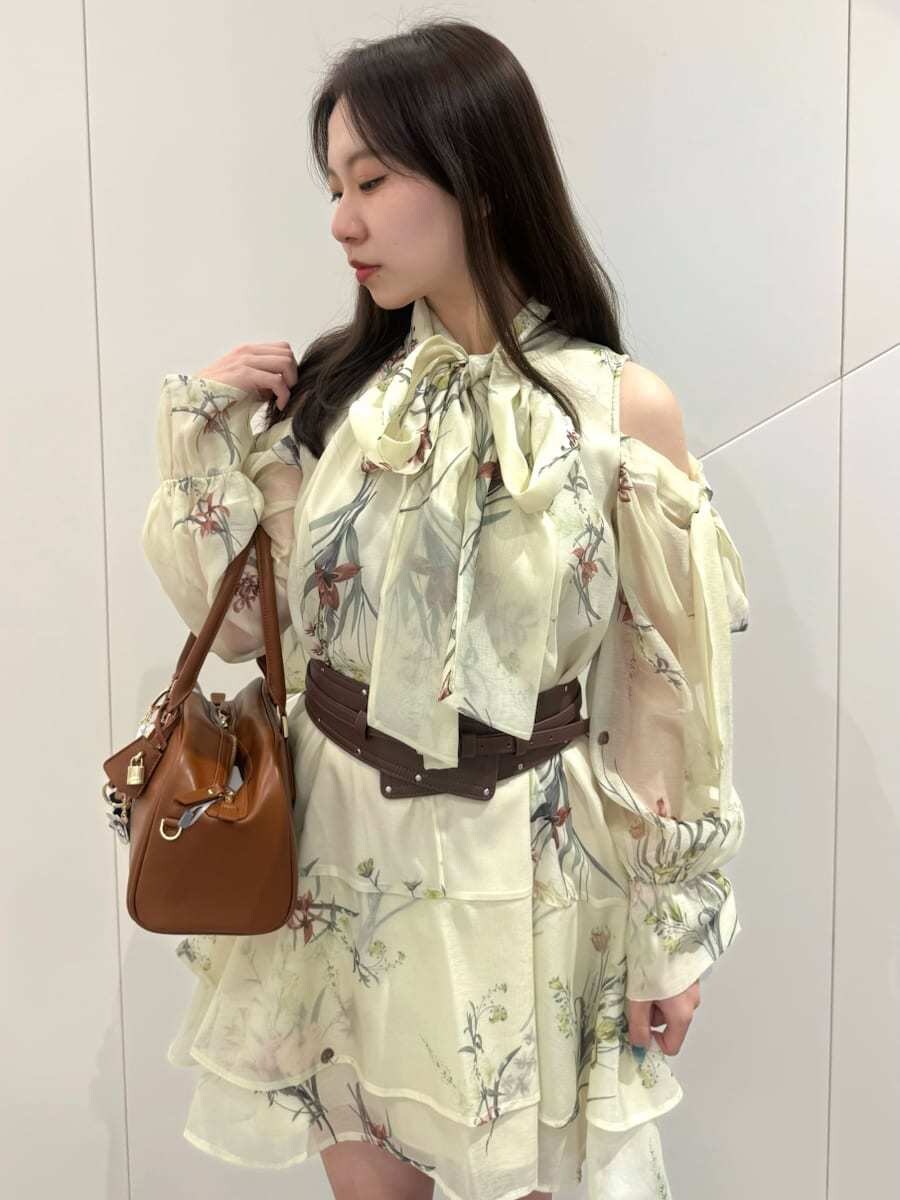 ブルー系のワンピース、イエロー系のボストンバッグ、ブラウン系のベルトを着用したレディースの冬コーディネートの6枚目の写真