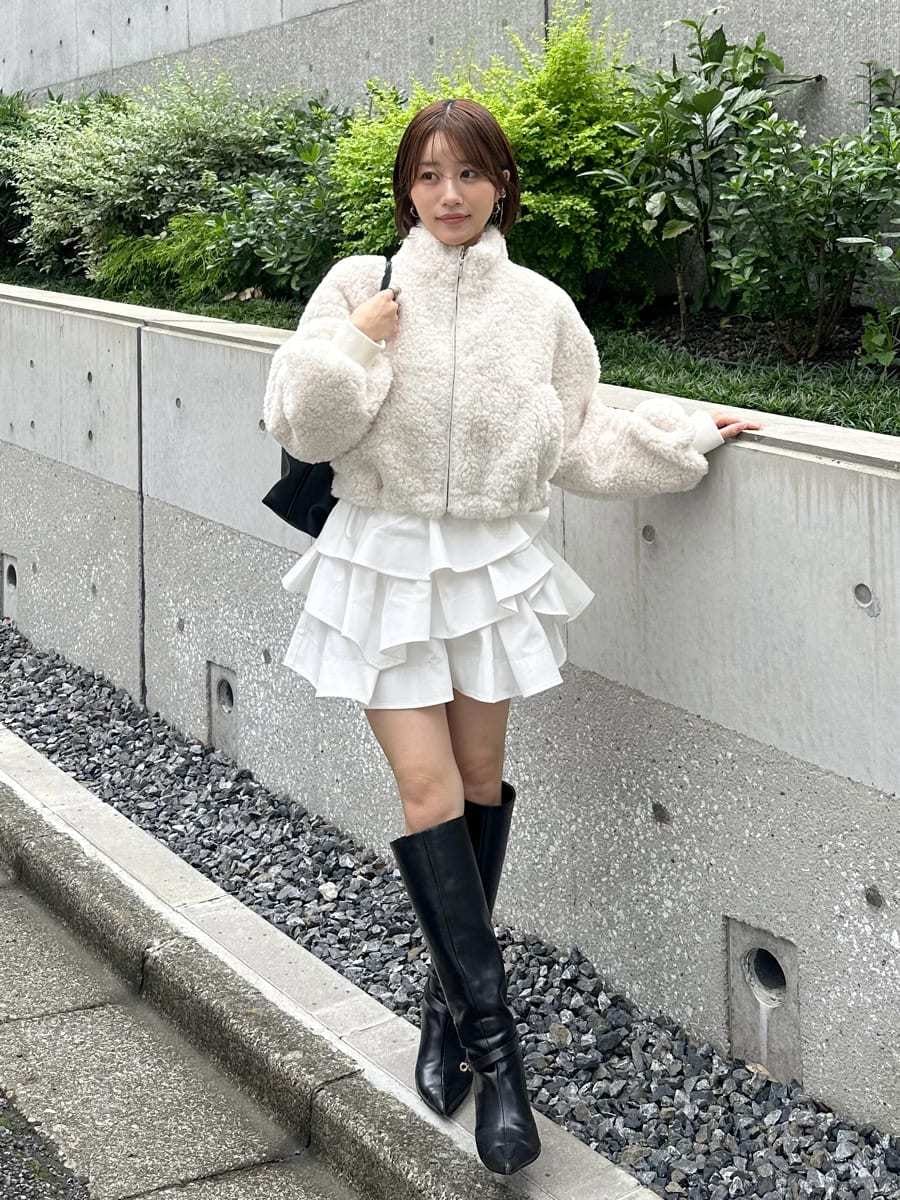 ホワイト系のその他パンツ、ブラック系のブーツ、ブラック系のショルダーバッグを着用したレディースの秋コーディネートの5枚目の写真