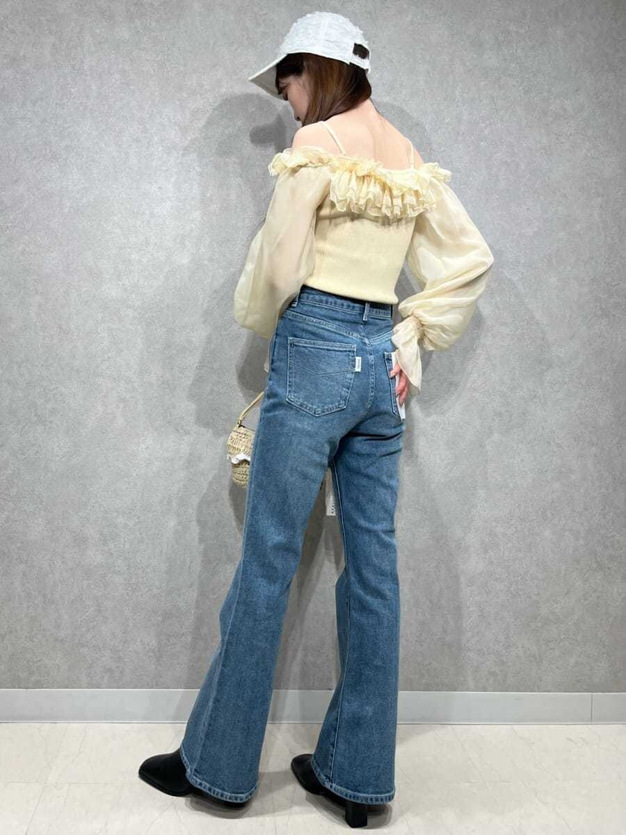 ブルー系のその他パンツ、イエロー系のニット/セーター、ホワイト系のキャップを着用したレディースの冬コーディネートの3枚目の写真