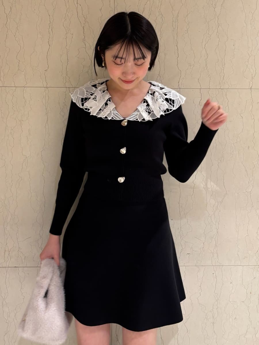 ブラウン系のブーツ、ホワイト系のハンドバッグ、ブラック系のワンピースを着用したレディースの冬コーディネートの5枚目の写真