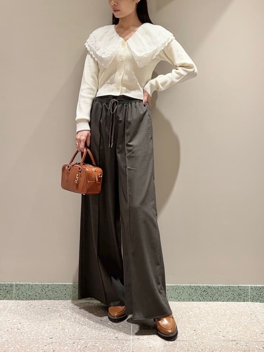 ホワイト系のニット/セーター、ブラウン系のその他パンツ、ブラウン系のボストンバッグを着用したレディースの秋コーディネートの2枚目の写真