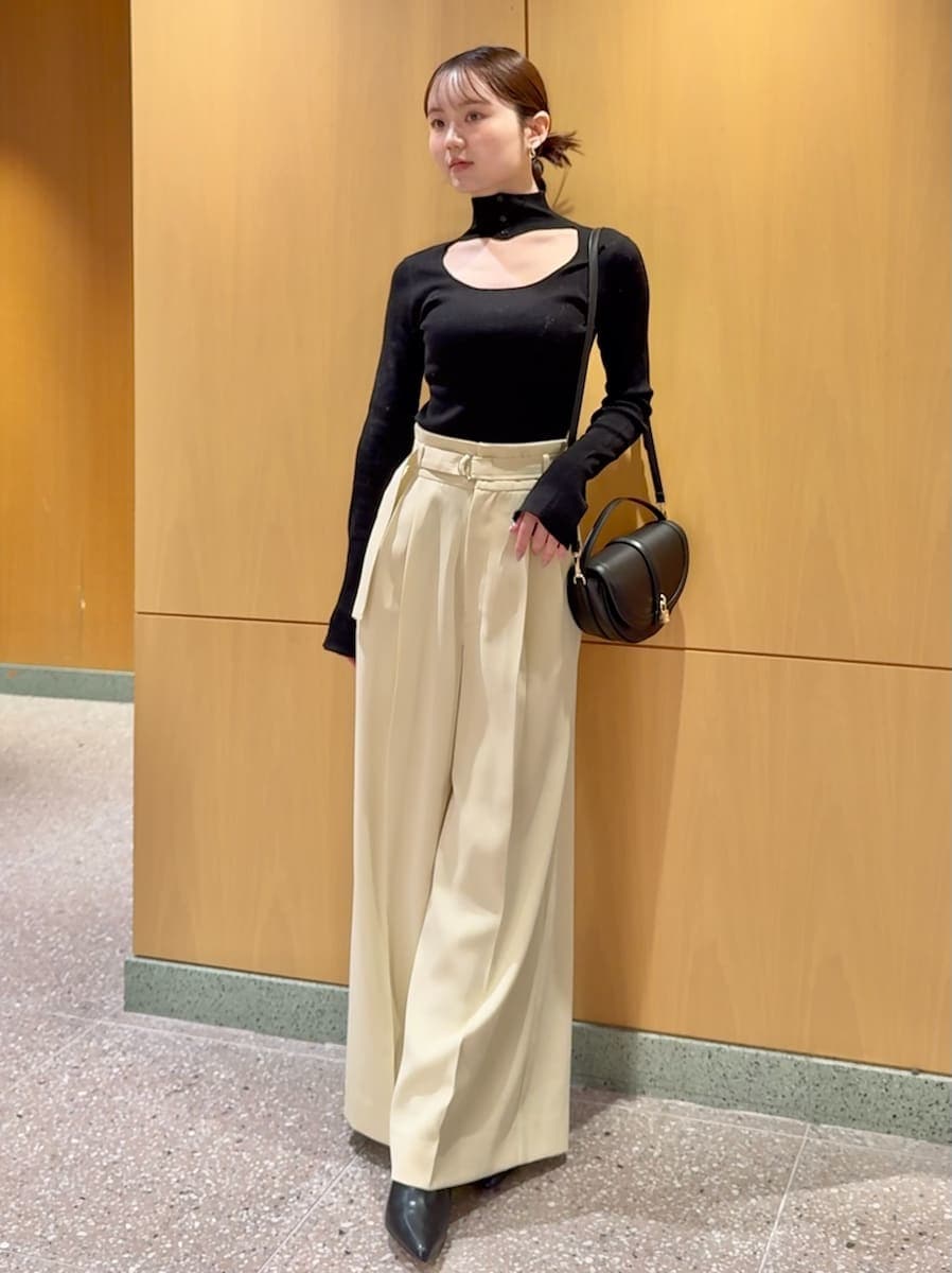 ホワイト系のカーディガン/ボレロ、ブラック系のニット/セーター、ブラック系のブーツを着用したレディースの秋コーディネートの4枚目の写真