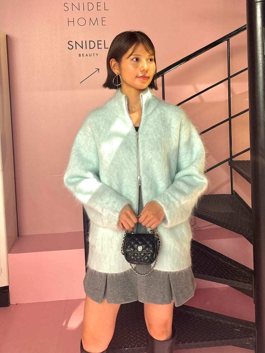 グリーン系のブルゾン、グレー系のスカート、ブラック系のショルダーバッグを着用したレディースの秋コーディネートの3枚目の写真