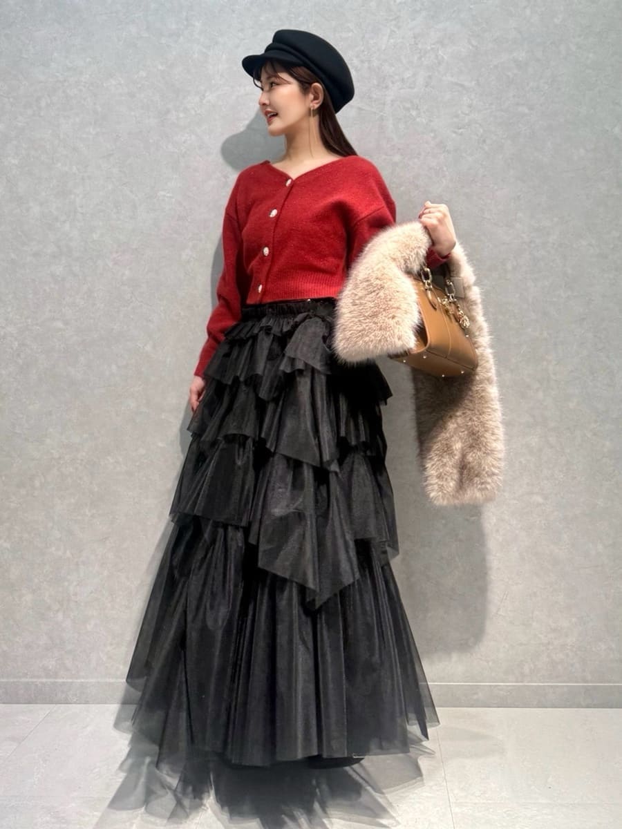 レッド系のブーツ、レッド系のカーディガン/ボレロ、ブラウン系のハンドバッグを着用したレディースの冬コーディネートの3枚目の写真