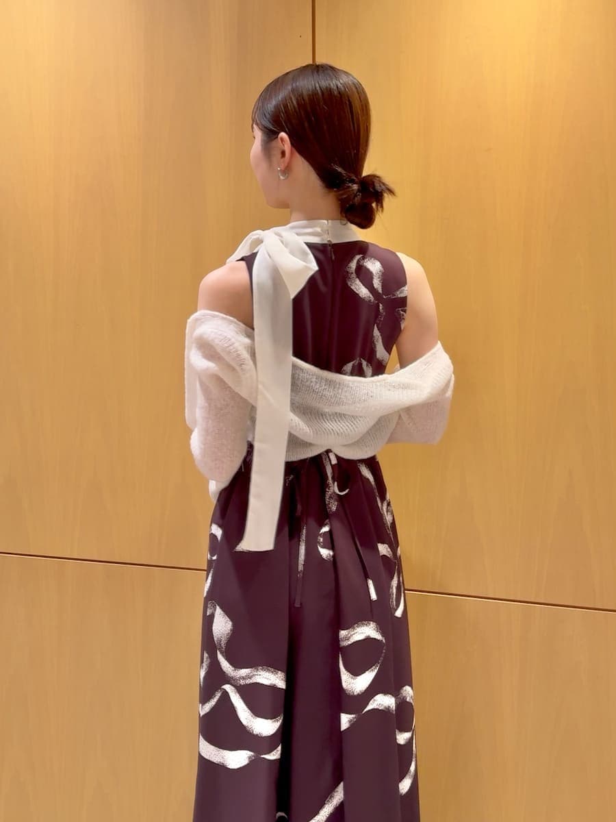 ホワイト系のショルダーバッグ、ブラウン系のワンピース、シルバー系のピアス（両耳用）を着用したレディースの冬コーディネートの8枚目の写真