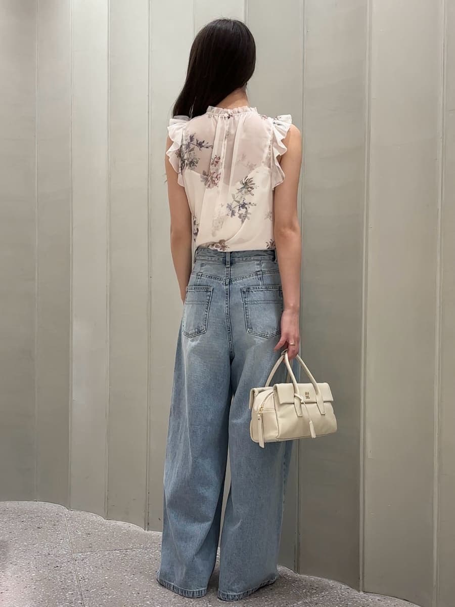 ホワイト系のボストンバッグ、ブルー系のデニムパンツ、ホワイト系のシャツ/ブラウスを着用したレディースの夏コーディネートの3枚目の写真