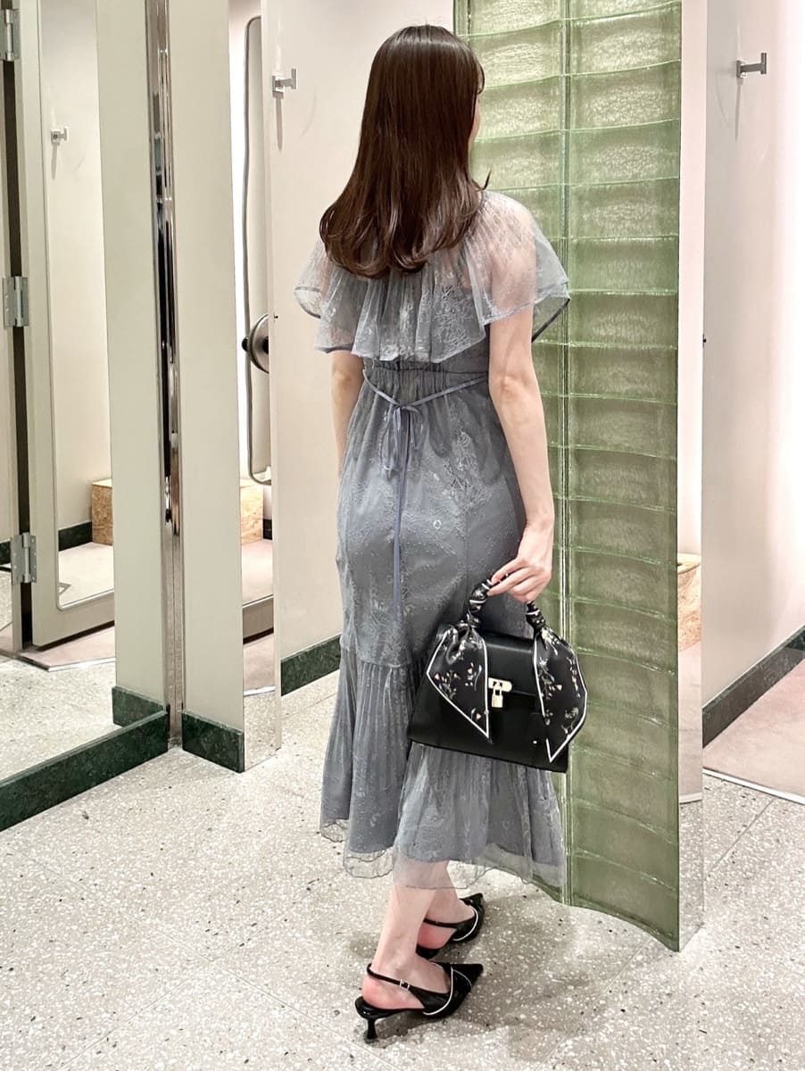 グレー系のドレス、ブラック系のパンプス、ブラック系のハンドバッグを着用したレディースの冬コーディネートの4枚目の写真