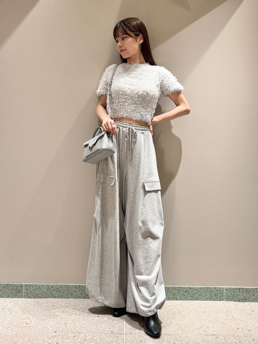 グレー系のニット/セーター、グレー系のその他パンツ、ブルー系のショルダーバッグを着用したレディースの夏コーディネートの2枚目の写真