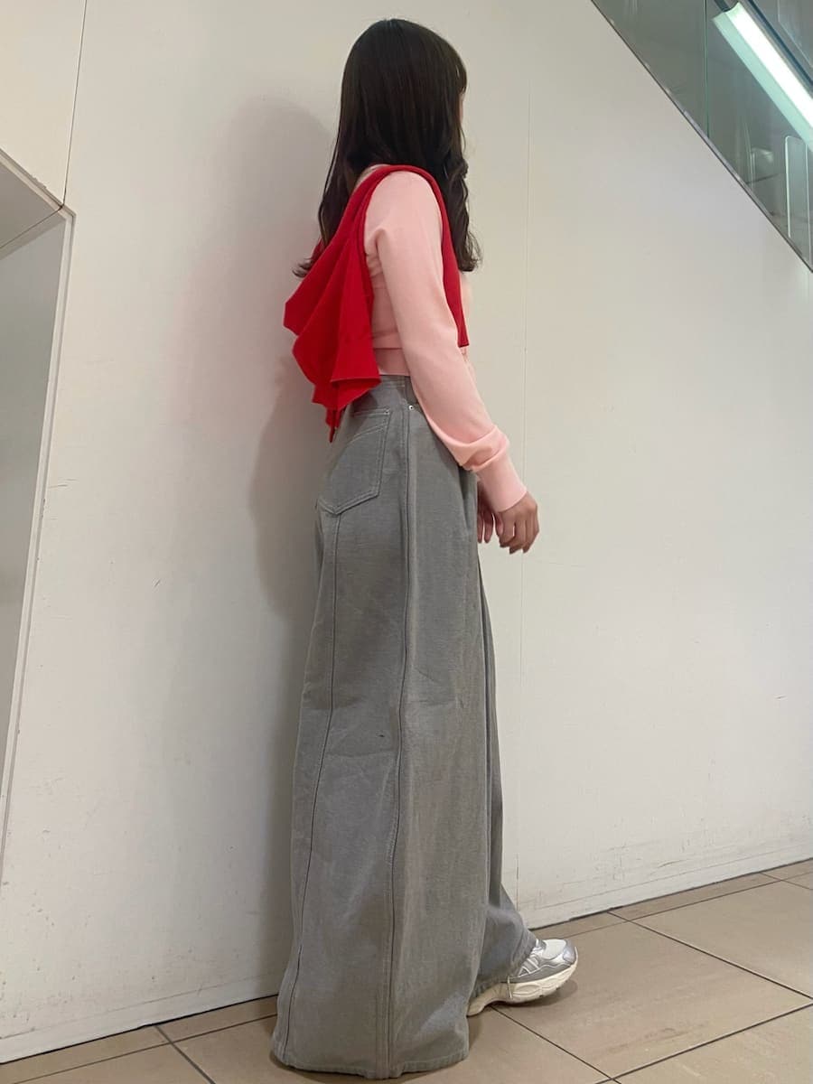 グレー系のデニムパンツ、レッド系のカーディガン/ボレロ、シルバー系のスニーカーを着用したレディースの冬コーディネートの3枚目の写真