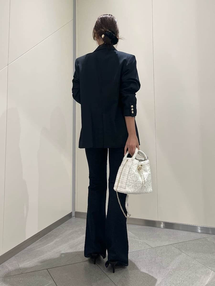 ブルー系のデニムパンツ、ブルー系のテーラードジャケット、ブルー系のキャミソールを着用したレディースの秋コーディネートの3枚目の写真