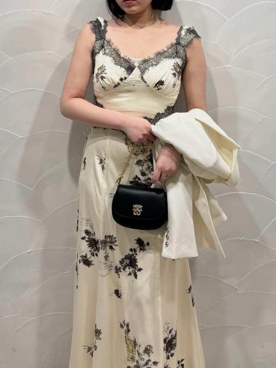 ホワイト系のテーラードジャケット、イエロー系のワンピース、ブラック系のパンプスを着用したレディースの春コーディネートの4枚目の写真