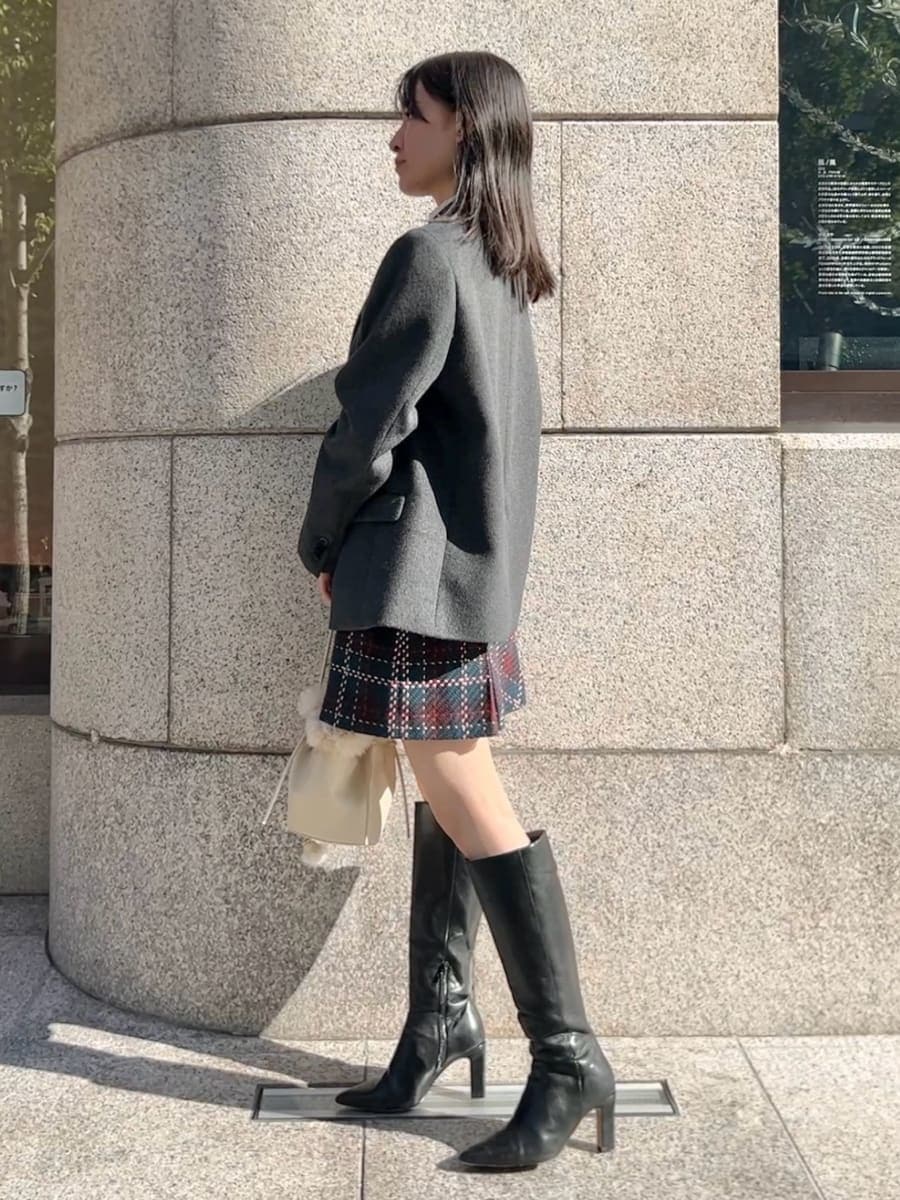 ホワイト系のニット/セーター、ブラック系のブーツ、グレー系のテーラードジャケットを着用したレディースの秋コーディネートの3枚目の写真