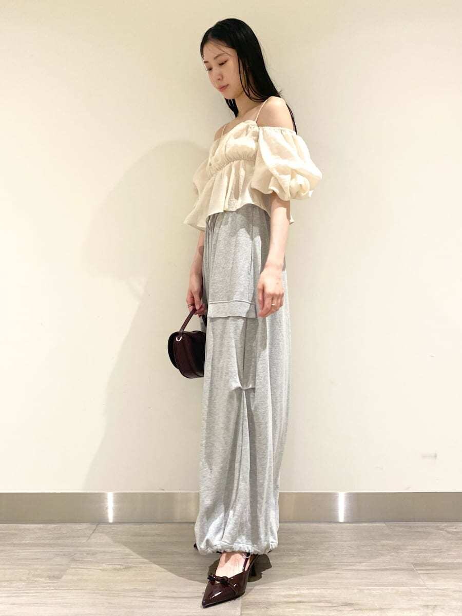 ホワイト系のシャツ/ブラウス、グレー系のその他パンツ、ブラウン系のハンドバッグを着用したレディースの秋コーディネートの3枚目の写真