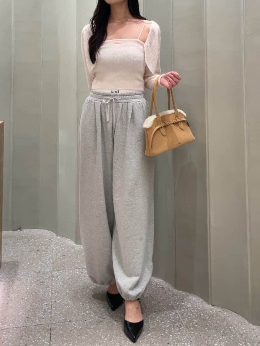グレー系のその他パンツ、ピンク系のカーディガン/ボレロ、ブラック系のパンプスを着用したレディースの秋コーディネートの4枚目の写真