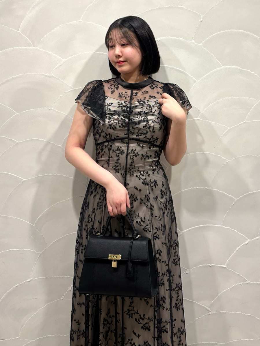 ブラック系のパンプス、ブラック系のハンドバッグ、ブラック系のドレスを着用したレディースの春コーディネートの4枚目の写真