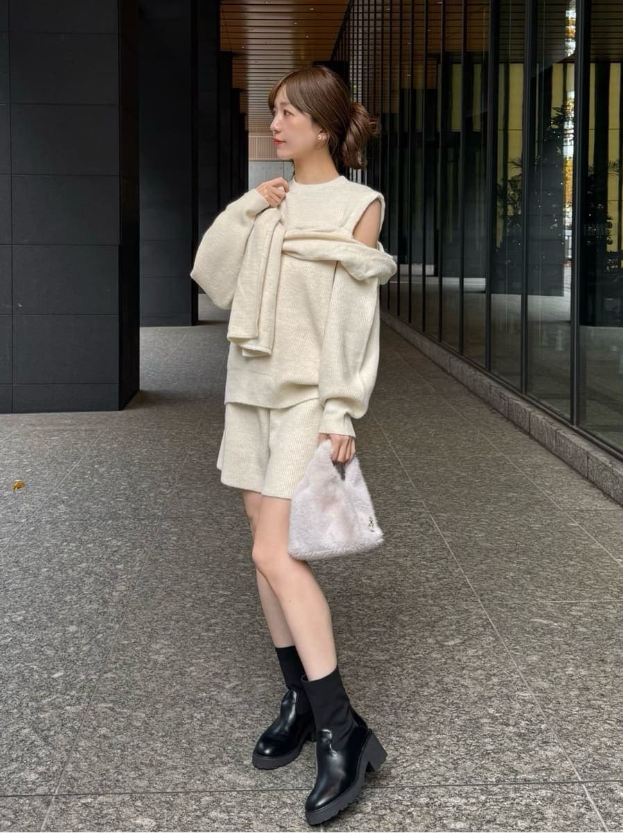ホワイト系のその他パンツ、ホワイト系のニット/セーター、ホワイト系のハンドバッグを着用したレディースの冬コーディネートの3枚目の写真
