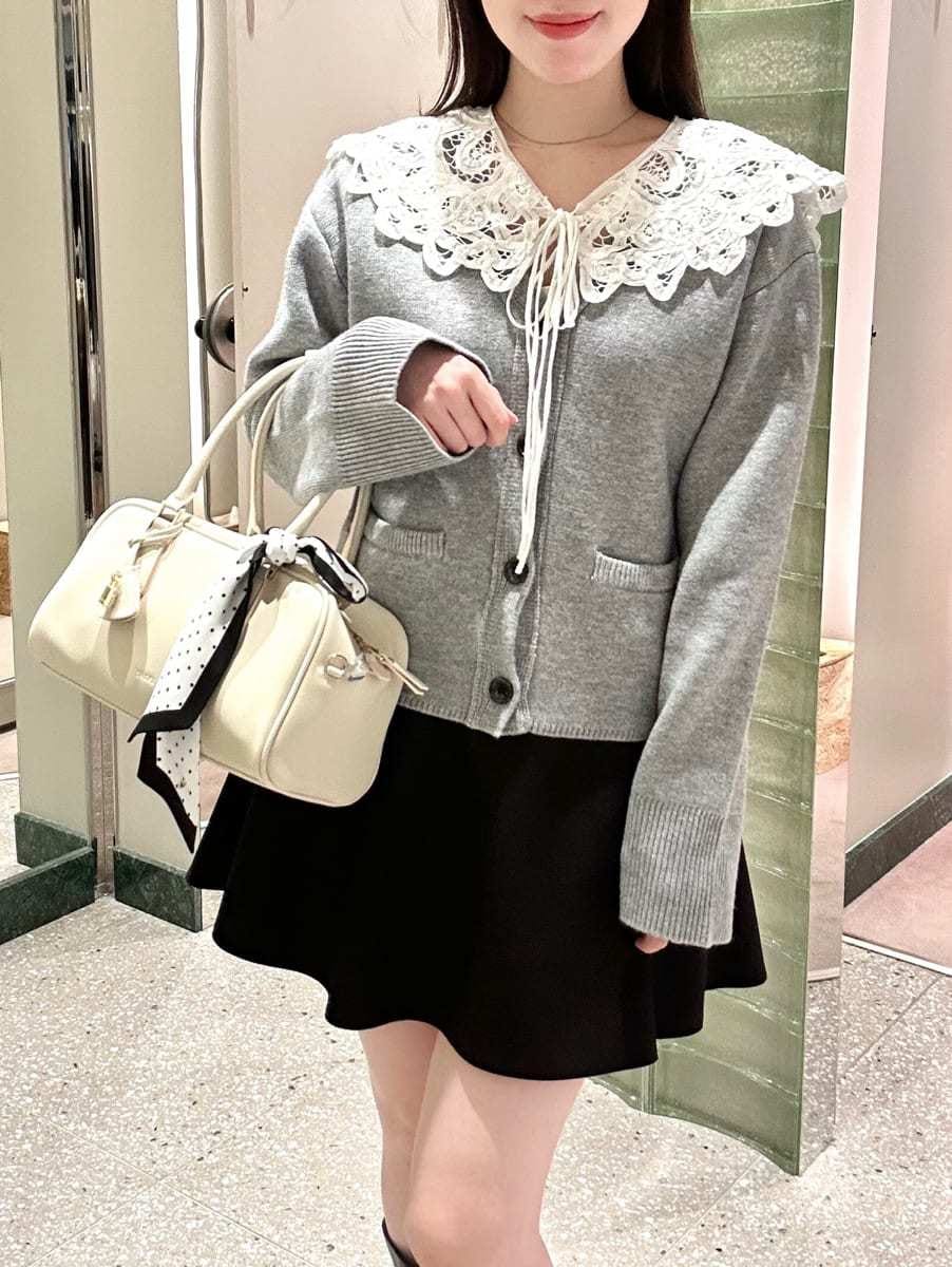 ブラック系のその他パンツ、グレー系のカーディガン/ボレロ、ホワイト系のボストンバッグを着用したレディースの冬コーディネートの2枚目の写真