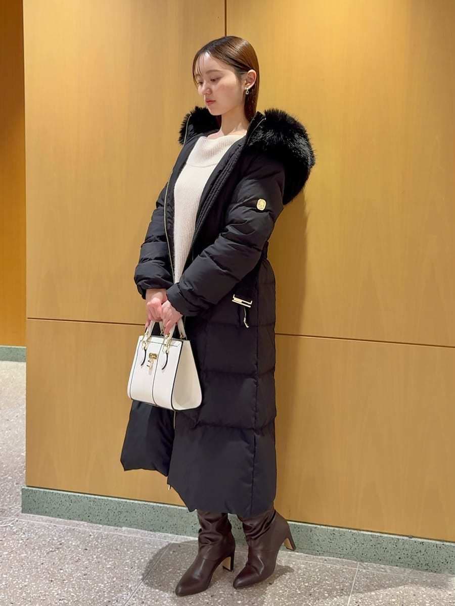ホワイト系のワンピース、ブラック系のダウンジャケット/コート、ホワイト系のハンドバッグを着用したレディースの冬コーディネートの4枚目の写真