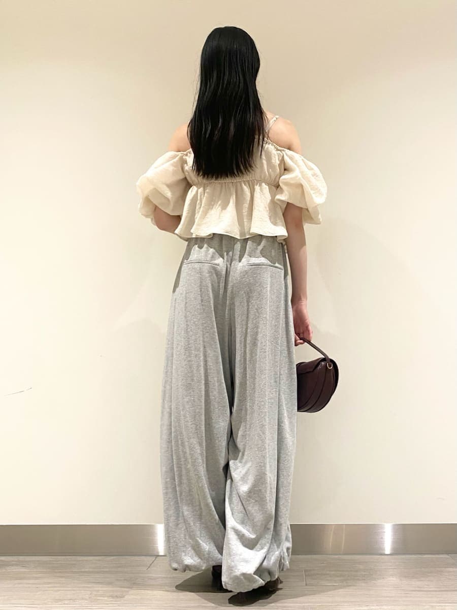 ホワイト系のシャツ/ブラウス、グレー系のその他パンツ、ブラウン系のハンドバッグを着用したレディースの秋コーディネートの4枚目の写真