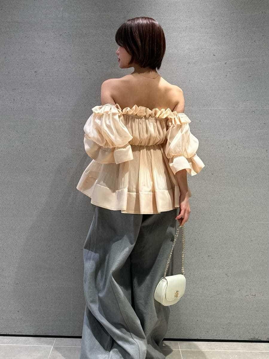 グレー系のデニムパンツ、オレンジ系のその他トップス、ブラック系のパンプスを着用したレディースの春コーディネートの5枚目の写真