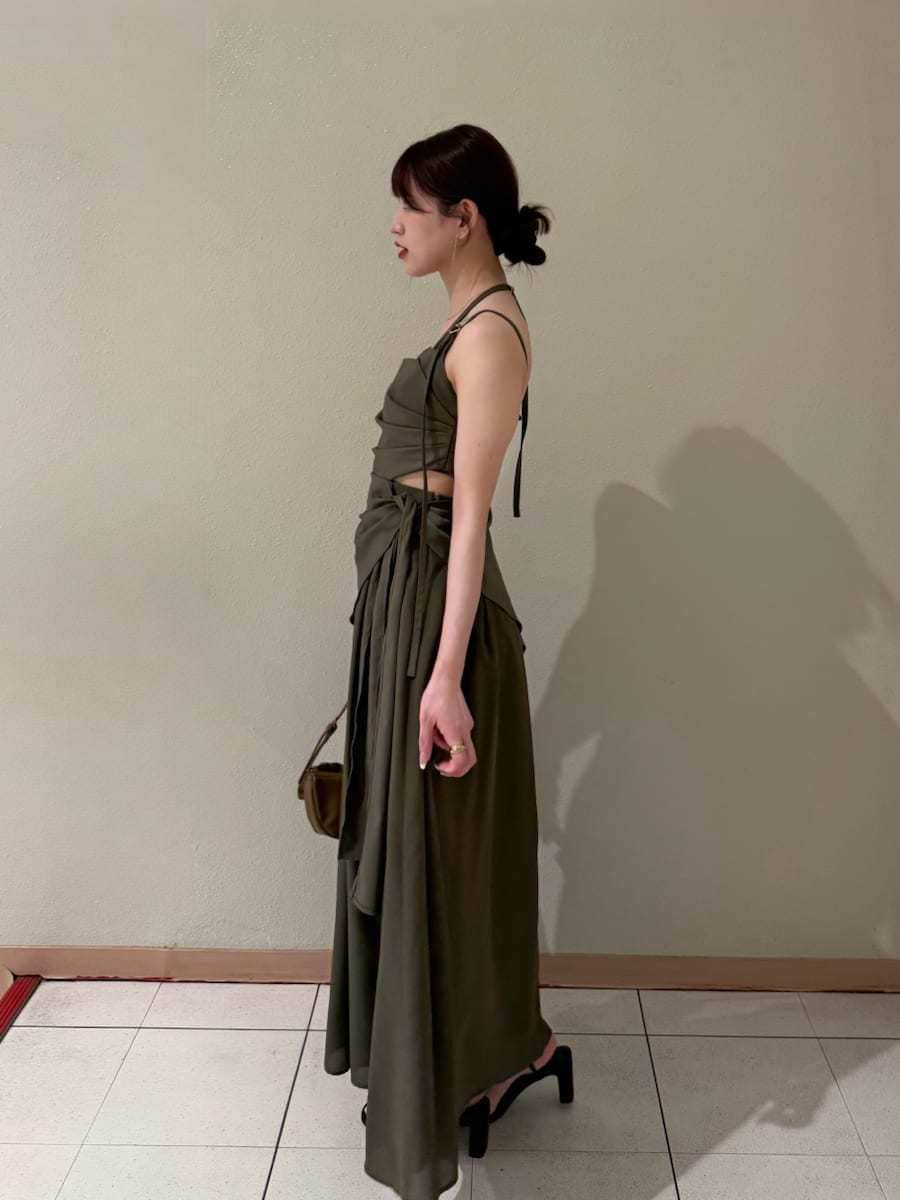 グリーン系のワンピース、ホワイト系のカーディガン/ボレロ、ブラウン系のハンドバッグを着用したレディースの春コーディネートの4枚目の写真