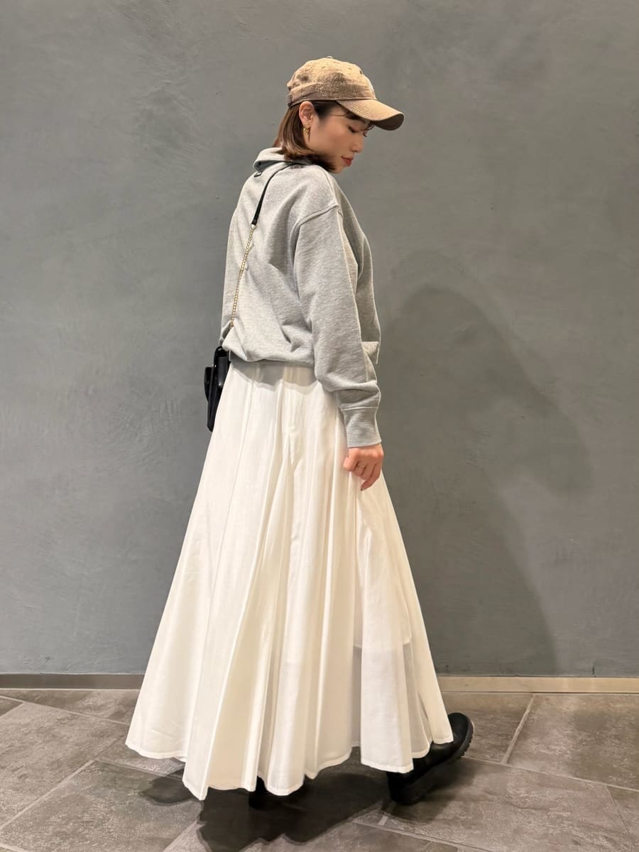 グレー系のスウェット、ブラック系のショルダーバッグ、ホワイト系のスカートを着用したレディースの春コーディネートの3枚目の写真