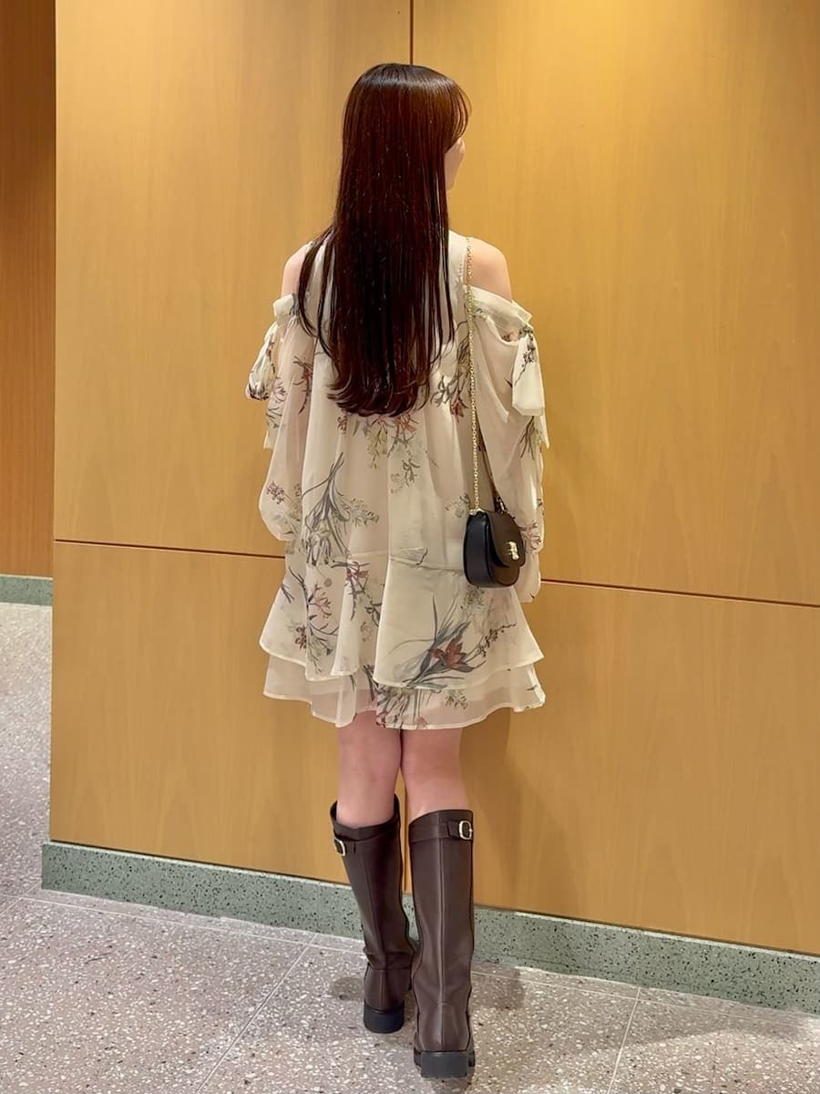 イエロー系のワンピース、ブラック系のショルダーバッグ、シルバー系のピアス（両耳用）を着用したレディースの冬コーディネートの4枚目の写真