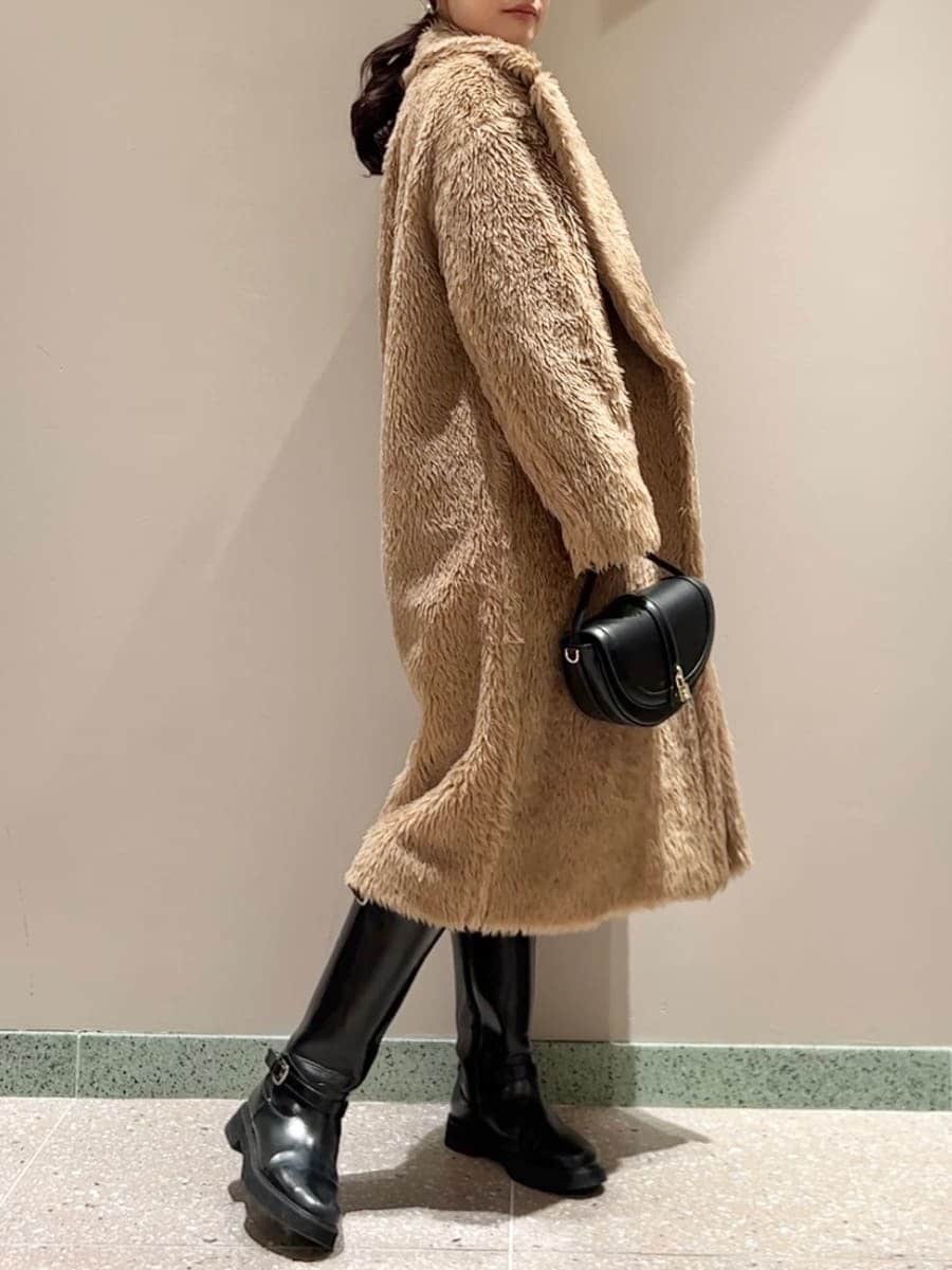 ブラック系のブーツ、ブラック系のハンドバッグ、ホワイト系のその他パンツを着用したレディースの冬コーディネートの3枚目の写真