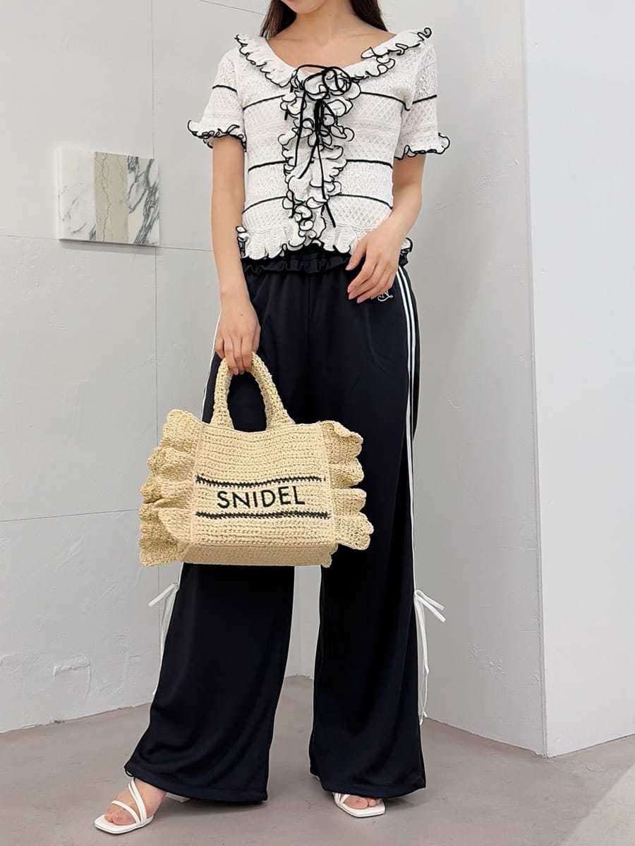 ベージュ系のショルダーバッグ、ブルー系のその他パンツ、ホワイト系のニット/セーターを着用したレディースの春コーディネートの2枚目の写真